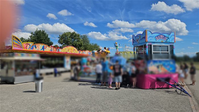 Chilbibahnen und Buden bei blauem Himmel